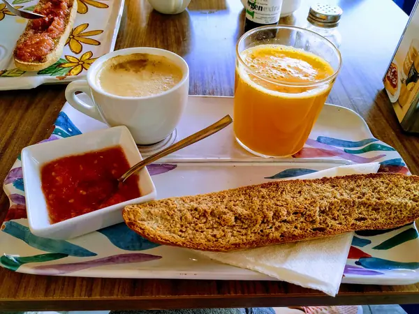 Desayuno con tostada de tomate, zumo de naranja y café con leche