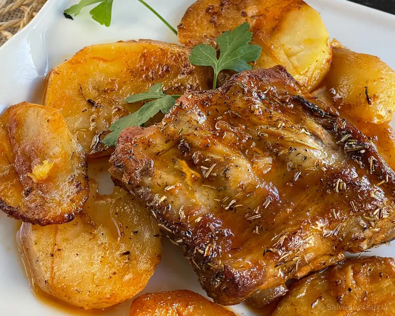 Carne asada glaseada con patatas panaderas y perejil fresco
