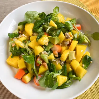 Ensalada de canónigos con dados de mango y zanahoria, vista desde arriba